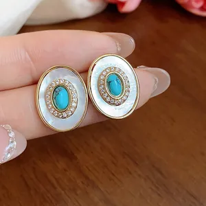 Close-up of vintage oval studs with mother of pearl and turquoise center stone