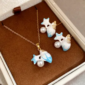 Detailed view of gold-tone jewelry set with blue starfish, pearls, and zircons in box
