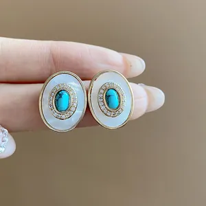 Detailed view of vintage oval stud earrings with turquoise and mother-of-pearl inlay.