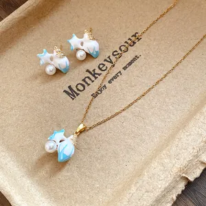Close-up of vintage starfish jewelry set with blue enamel, pearls, and zircons on a tray.