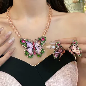Ornate vintage butterfly necklace and earrings set with colorful rhinestones and amber beads