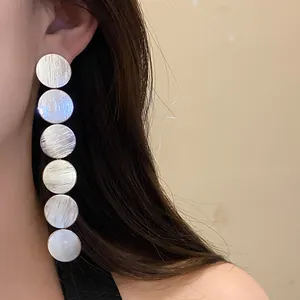 Close-up view of elegant silver textured multi-circle long drop earrings on model