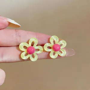 Vue détaillée de boucles d'oreilles fleurs jaunes et roses de style dopamine