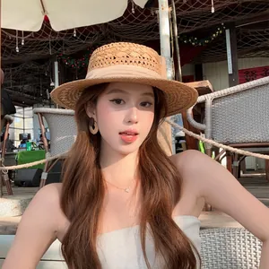 Elegant resort style brown rattan woven circle earrings worn by a model in a cafe