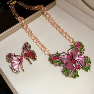Detailed view of a vintage butterfly jewelry set with pink resin wings and green crystals