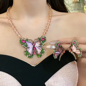 Close-up of vintage butterfly jewelry set with pink and green rhinestones and resin