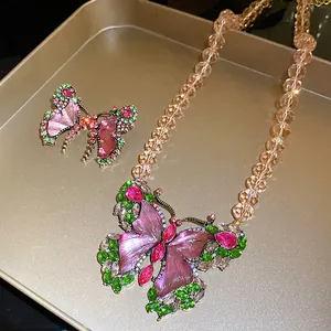 Detailed view of vintage butterfly necklace and earrings set with pink resin stones