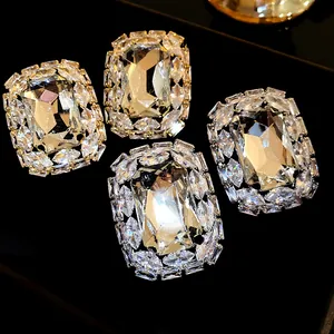 Close-up detail of luxury square-cut rhinestone stud earrings with silver needles.