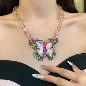 Detail view of a vintage butterfly pendant necklace with colorful rhinestones on a model