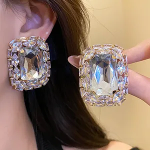 Detail shot of sparkling rectangular crystal stud earrings with halo diamonds