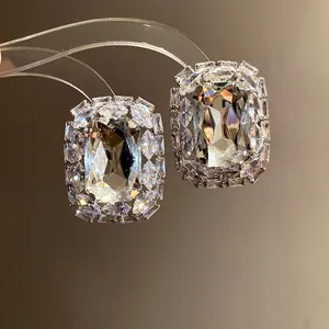 Detail view of luxurious square earrings with radiant clear gemstones and silver finish