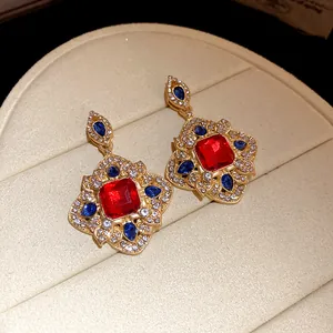 Detailed macro view of vintage court style dangle earrings with red and blue gemstones
