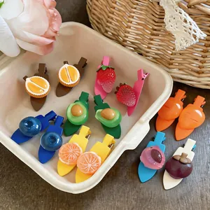 Vue détaillée de jolies pinces à cheveux fruits colorés dans un panier de paille