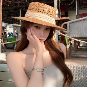 Lifestyle detail of woman wearing resort-style rattan hoop earrings in a sunny outdoor setting.