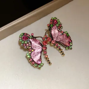 Close-up of a vintage butterfly jewelry piece with pink resin and colorful rhinestones.