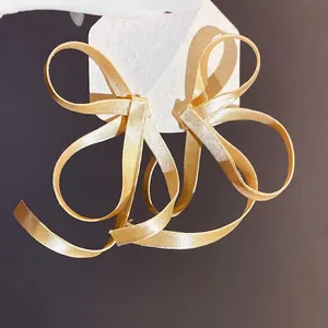 Eleganti orecchini a fiocco in nastro color champagne con trama di seta per donna
