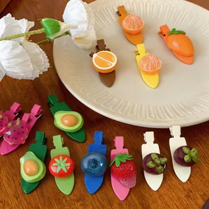 Gros plan sur des barrettes à cheveux en résine avec des motifs de fruits colorés
