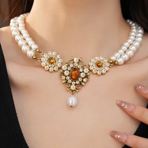 Macro view of a luxury vintage double-layer resin pearl necklace with a golden jewel pendant