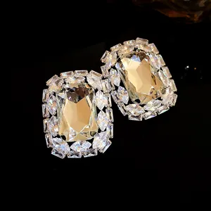 Close-up of elegant silver stud earrings featuring large rectangular shimmering clear stones