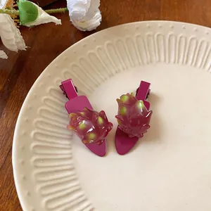 Gros plan de deux barrettes à cheveux en forme de fruit du dragon sur une assiette