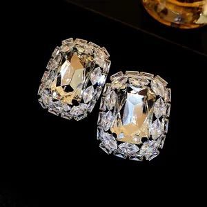 Close-up detail of luxury oversized square earrings featuring shimmering clear crystals