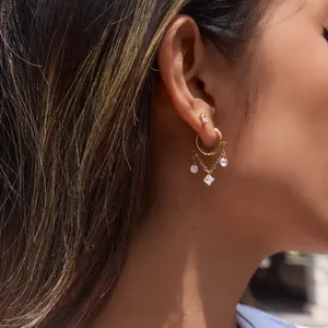 Elegante goldene Edelstahl-Ohrringe mit glitzernden Zirkonia-Anhängern am Modell gezeigt