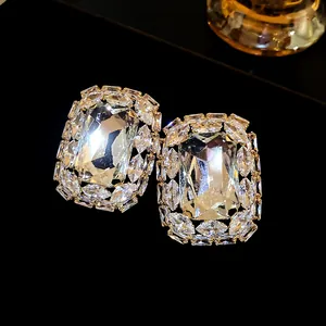 Macro view of luxurious square stud earrings with shimmering emerald-cut clear stones