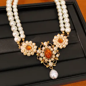 Close-up of vintage court style double strand pearl necklace with amber resin stones