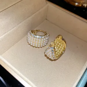 Detaillierte Nahaufnahme von eleganten Vintage-Creolen mit Perlen und Strass in Gold