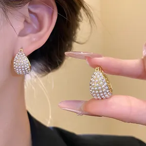 Detailansicht von Vintage-Creolen mit kleinen Perlen und glitzernden Kristallen.