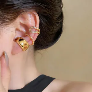 Detailed view of three gold ear cuffs including a crystal pavé and polished band design