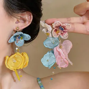 Detailed close-up showing the handmade chiffon flower tassel earrings with beads