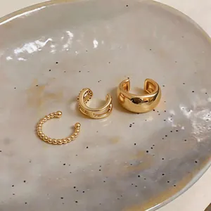Elegant gold-plated non-piercing ear cuff set for women presented on ceramic plate