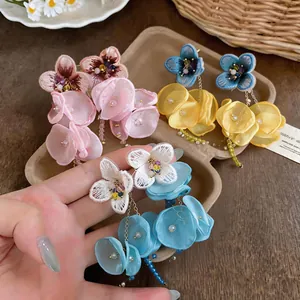 Close-up detail of elegant handmade chiffon flower tassel earrings in pastel colors