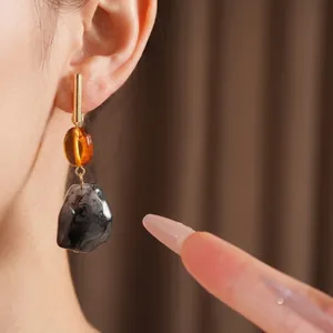 Pendientes colgantes vintage de resina con texturas de ámbar y mármol vistos en modelo
