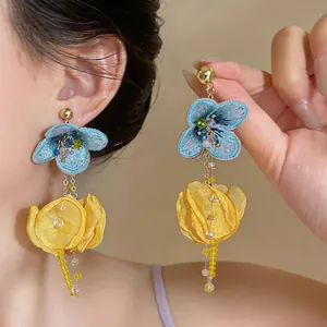 Detailed view of handmade blue and yellow chiffon flower tassel earrings for vacation.