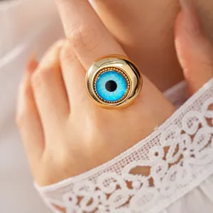 Primo piano dettagliato di un anello occhio del diavolo dorato con iride in resina blu