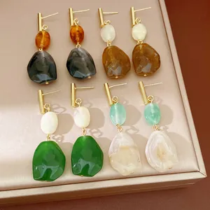 Primer plano detallado de varios pendientes geométricos de resina en colores vivos