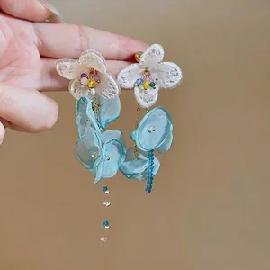 Close-up of elegant blue chiffon flower tassel earrings with intricate lace details.
