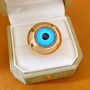 Primo piano di un anello dorato Evil Eye con iride blu vibrante in una scatola regalo