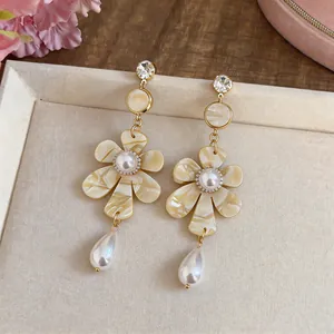 Vintage French style floral drop earrings with pearls and crystal accents on a tray