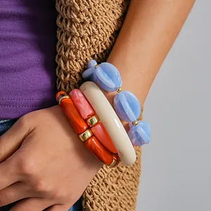 Macro view of colorful marbleized acrylic stretch bracelets on a woman's slender wrist