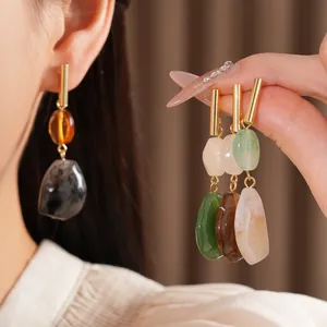 Detalle de pendientes geométricos de resina con estilo étnico vintage y acentos dorados