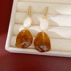 Primer plano de pendientes colgantes de resina de ámbar vintage