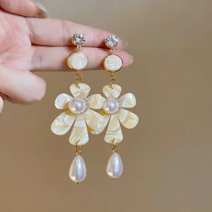 Close-up of vintage French floral earrings with pearl and rhinestone details
