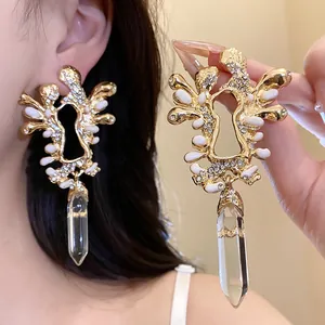 Primo piano dettagliato di orecchini vintage dorati con strass e pendenti di cristallo
