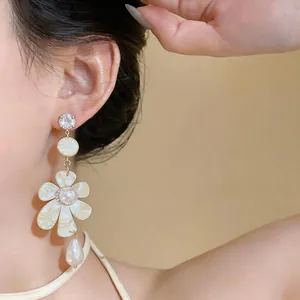 Close-up of vintage French style floral earrings with pearls worn on model's ear lobe
