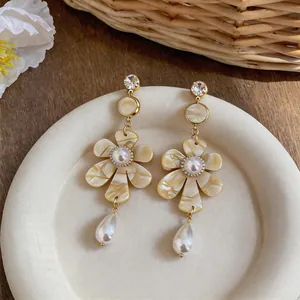 Detailed view of vintage French flower earrings with pearls and sparkling crystal accents