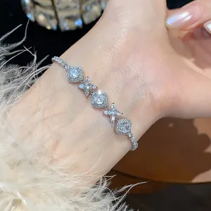 Macro view of French style cubic zirconia flower and rhombus bracelet on woman's wrist
