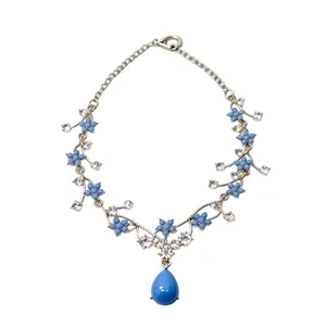 Elegant floral silver-toned necklace featuring blue resin flowers and teardrop crystal pendant